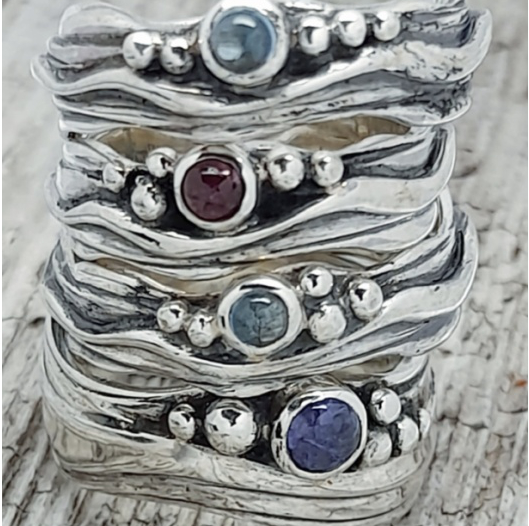 stack of narrow wave rings in silver with gems